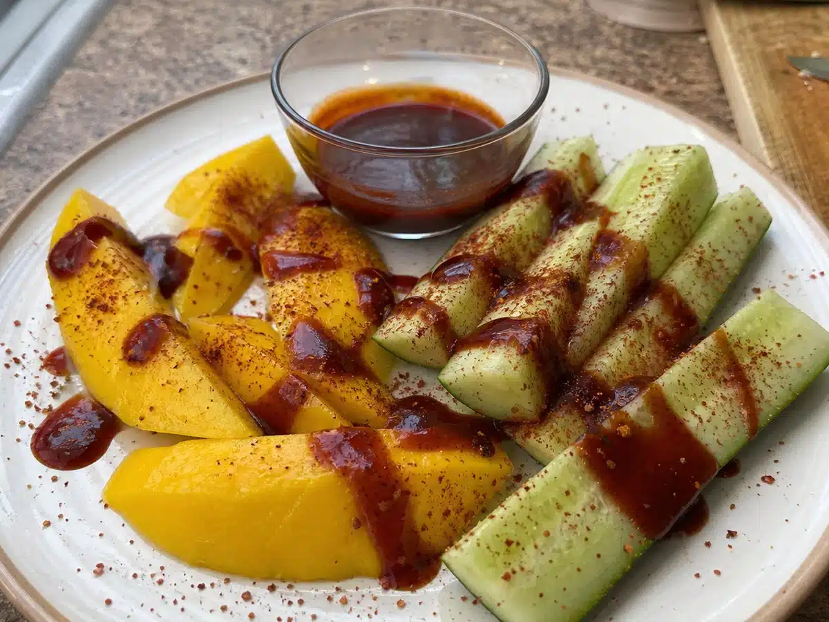 Best chamoy sauce drizzled over fresh mango and cucumber spears