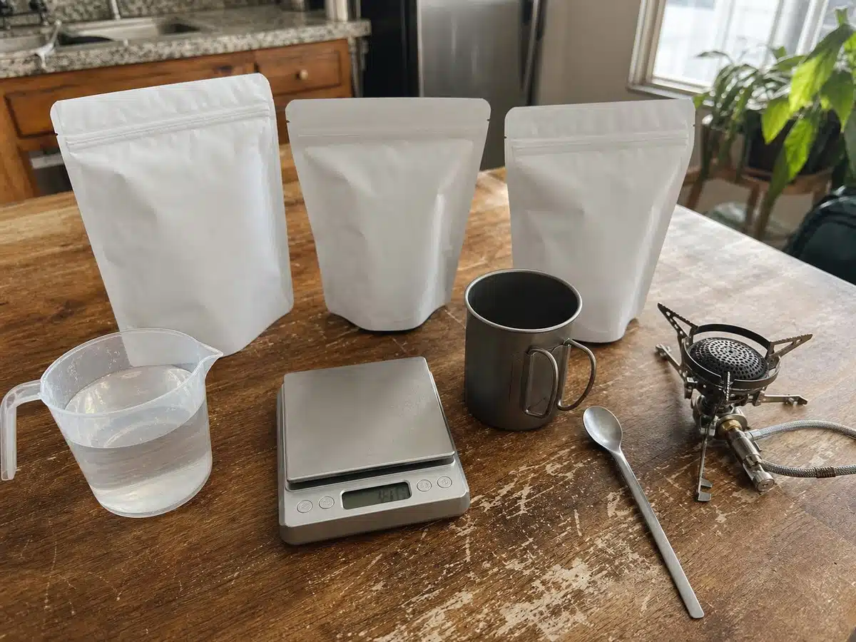 Unbranded freeze-dried meal pouches with water, stove, mug, spoon, and scale for best freeze-dried meals