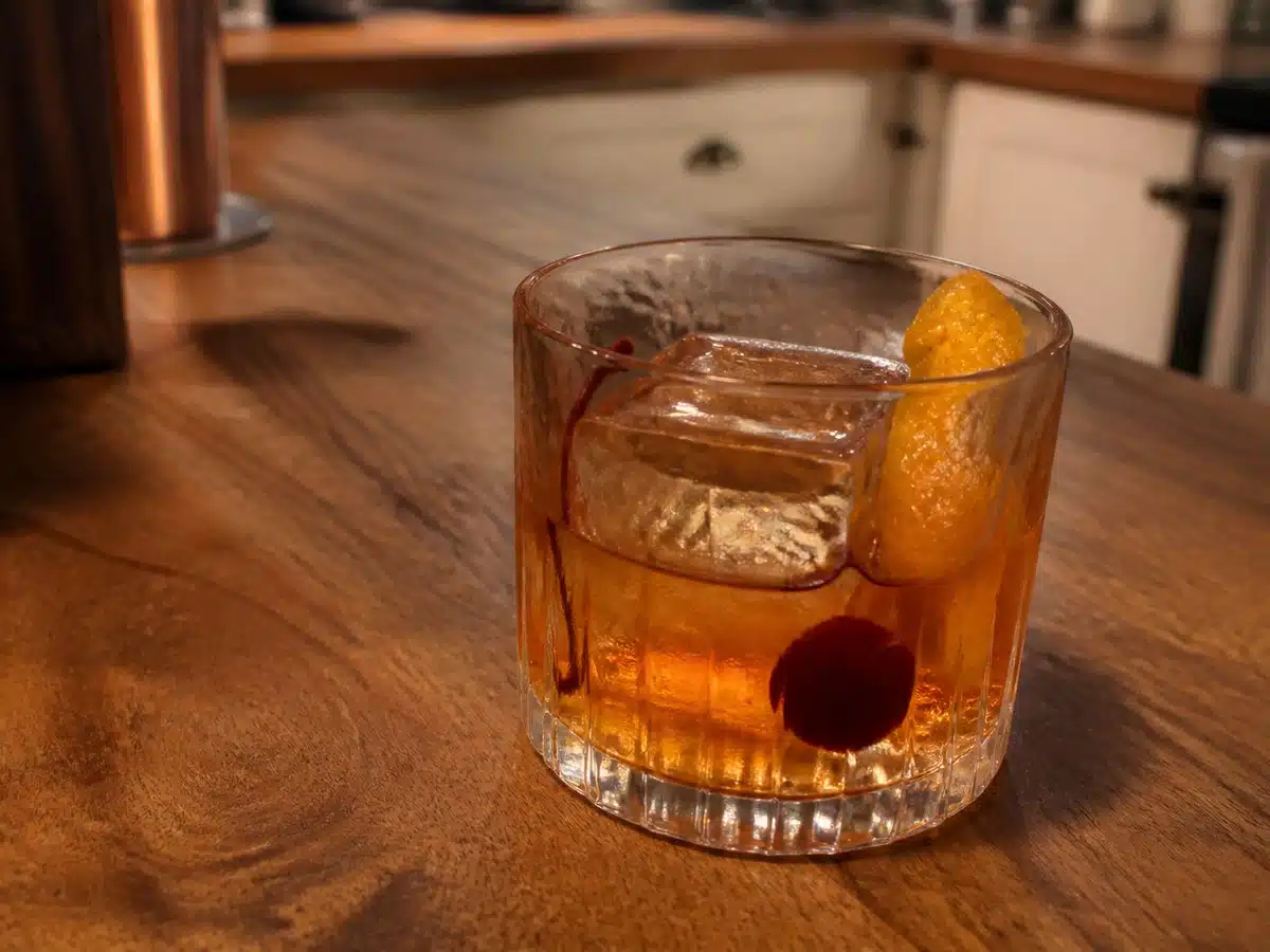 Best old fashioned mix: an amber old fashioned cocktail over ice with orange peel and cherry