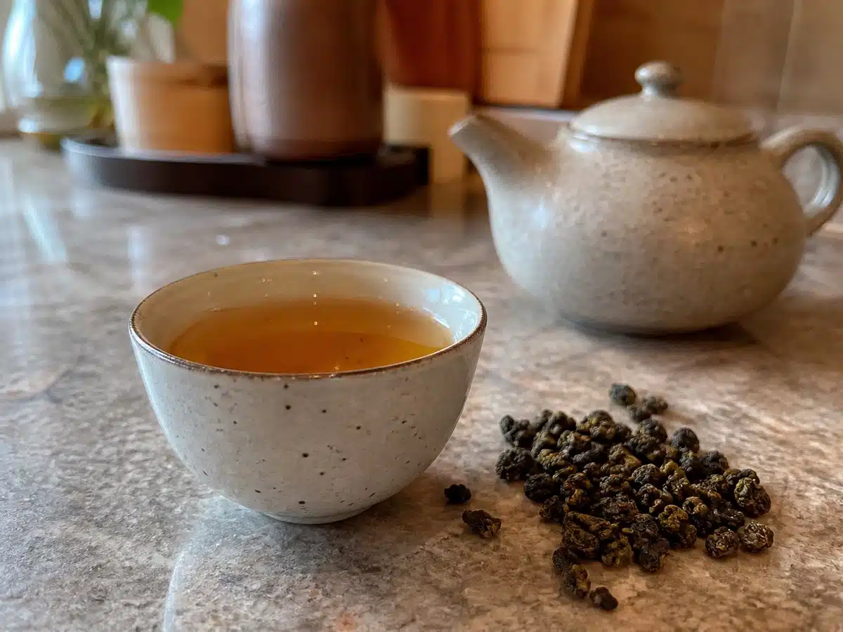 Best oolong tea: a cup of amber oolong tea with loose rolled leaves